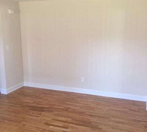 livingroom with hardwood floors enter from apartment door.
