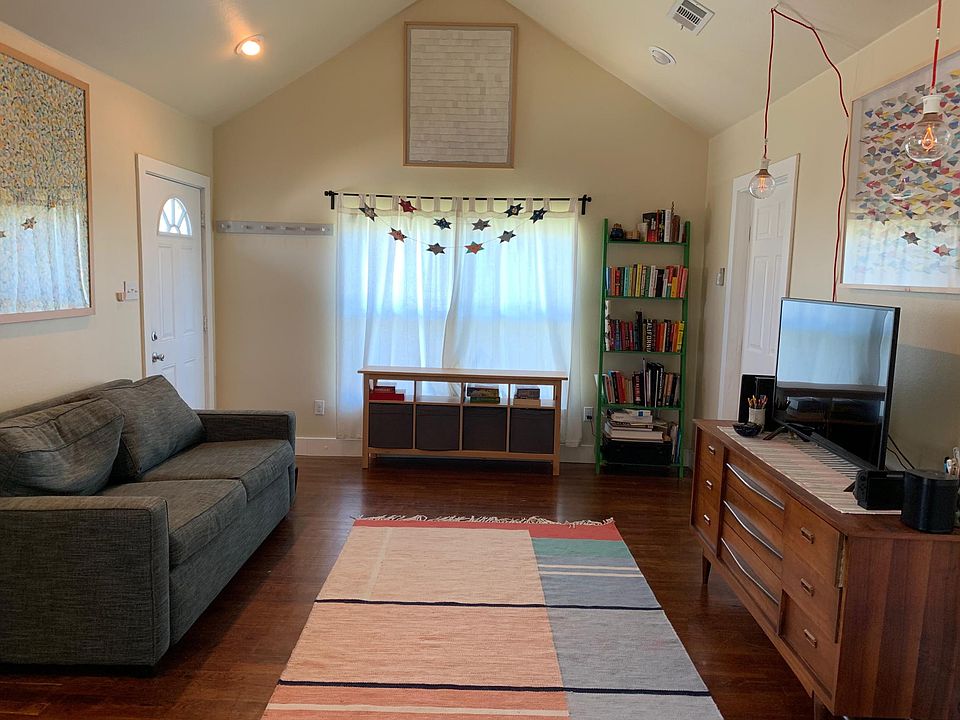 living room, with front door and door to first bedroom