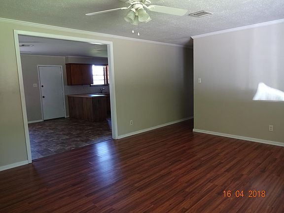 Living room facing combo dining/kitchen and hallway