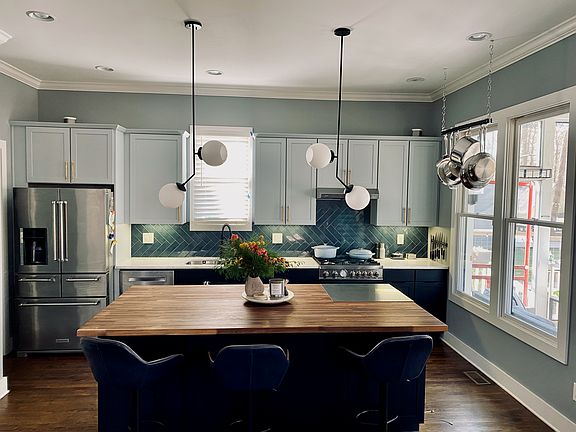 Bright kitchen with quartz countertops, a butcher block island and professional range