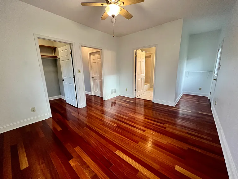 Primary bedroom.
Door on left is walk in closet. Open door is the main entrance to room. Door in middle is to primary bathroom. Door one right is to private deck.
