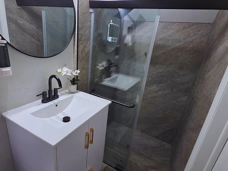 Stylish vanity with cabinet, mirror, liquid soap and fresh towels included.