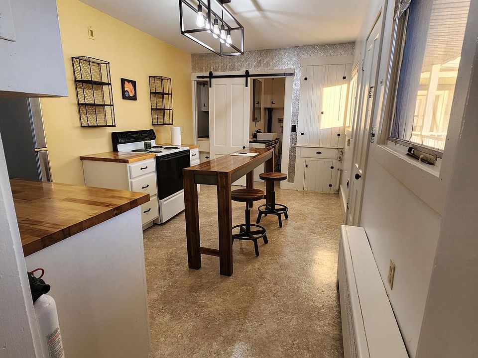 Kitchen with center island and stools.. brand new stainlesss steel fridge.