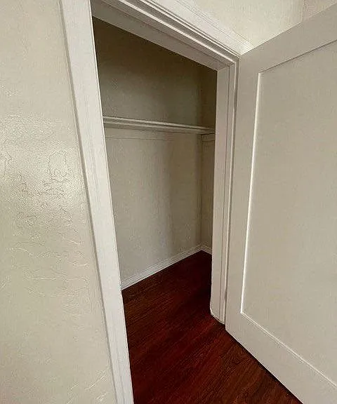 Walk-in closet and beautiful hardwood flooring in bedroom at Molino Del Mar Apartments in Pasadena, California.