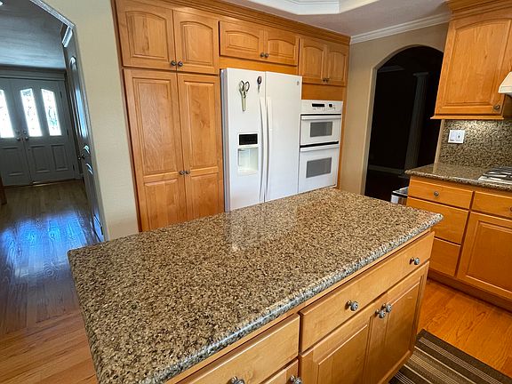 Kitchen with island cabinet and granite counter top.