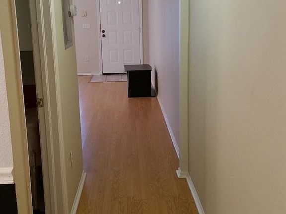 Floating hardwood flooring in downstairs Hallway. Unique slim columns accent the walls every few feet. Designer flush mount lighting shines to illuminate your path as you go.