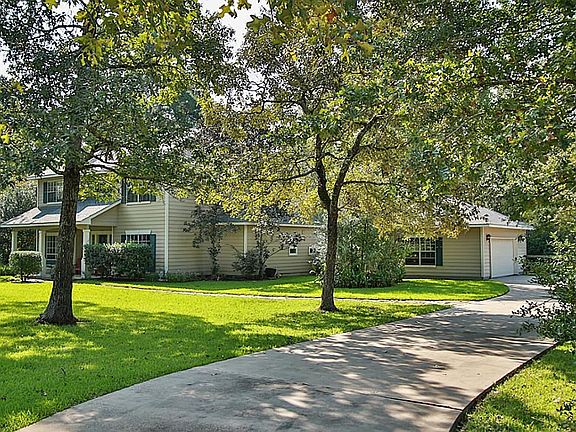Home set back off the street with concrete driveway up to the detached garage.