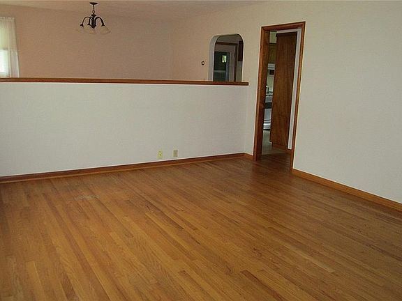 This view of the other side of the Greatroom shows the half-wall that was built to define the Dining Room - it literally sits on top of the hardwood floor and can easily be removed to create an great open layout!
