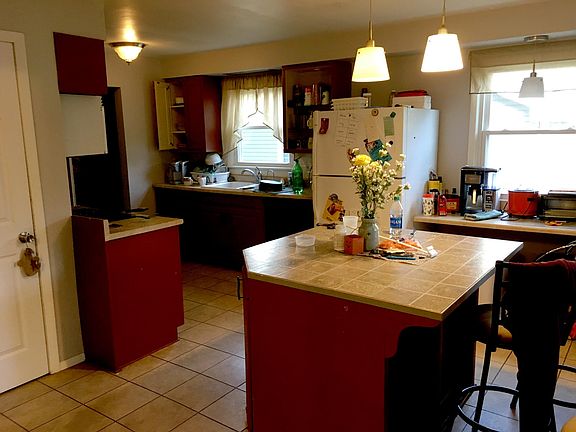 Large Kitchen. Garbage despoil, dishwasher, island, fridge, flat top stove/oven, large closet for storage.