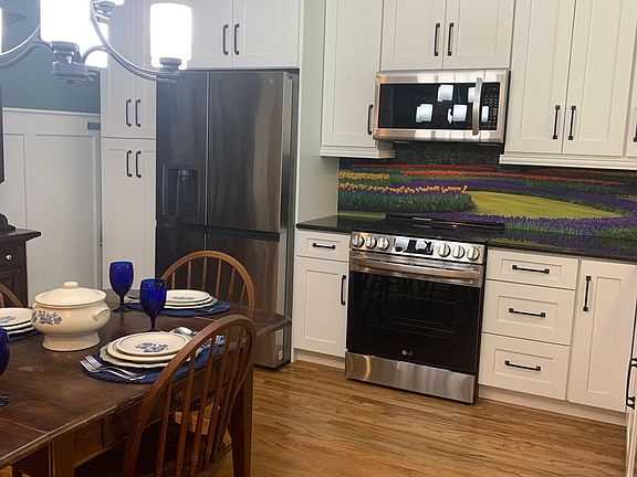 As you walk in the front door, on the right is your eat-in kitchen with a beautiful mural and under cabinet lighting.