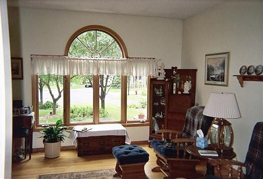 Main level Living Room has large bay windows and hardwood flooring.