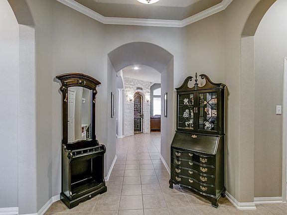 Welcome your guests through your entry with an elegant rotunda with tray ceilings, double crown molding, upgraded fixtures and upgraded fixtures entering into the main living area of the home