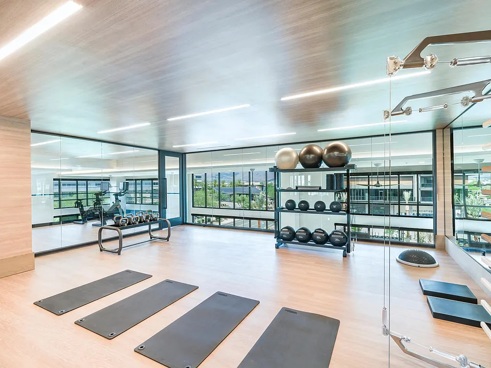 Stretch, lift, or flow in the light-filled fitness studio featuring yoga mats, weights, and floor-to-ceiling mirrors.