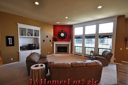 Open and spacious great room with 11' ceilings, custom trimmed windows with large transoms, gas fireplace and custom entertainment unit. 