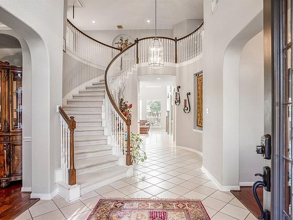 Welcoming entry leads to a circular staircase with Juliet balcony on the second living area of the home.