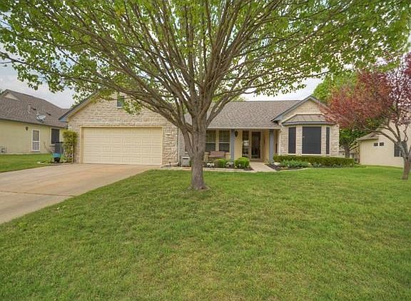 A pretty Red Bud is a harbinger of Spring at this nicely landscaped Sun City Texas Trinity Premier Home.