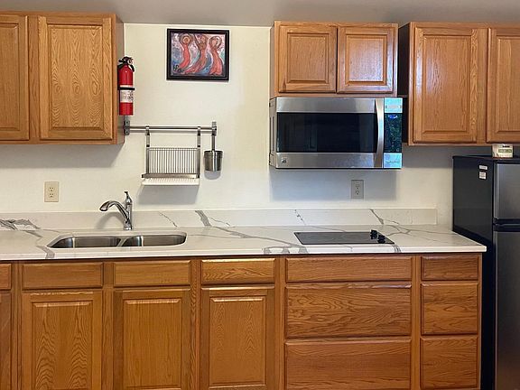 Well equipped kitchen with marble countertop and combination microwave/convection oven