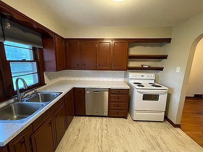 Kitchen with tile backsplash, double sink, dishwasher, disposal, plenty of storage