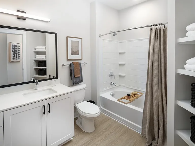 Bath with white shaker cabinetry, white quartz countertops, and hard-surface vinyl place flooring