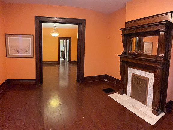Large sunny living room with original light fixtures and decorative ifireplaces