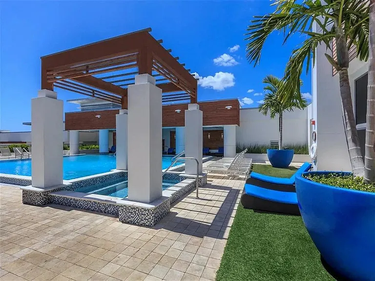 Enjoy the perfect blend of sun and shade by the pool, with a stylish pergola and palm tree adding a touch of paradise.