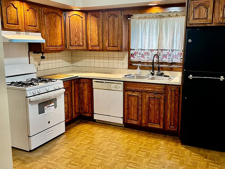 A clean kitchen featuring a brand-new gas range, and polished cabinetry. Equipped with a dishwasher and a large refrigerator, offering everyday convenience. A functional and inviting space designed for easy cooking, storage, and meal preparation.