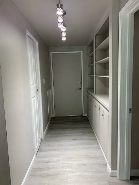 Entry with built in book case, storage underneath, and closet
