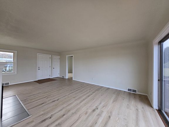 View of living room, looking towards entry. Coat closet on the right.