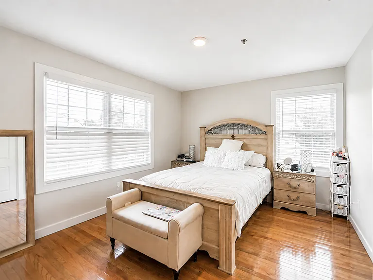 Large, sun-filled bedroom with multiple windows and generous living space