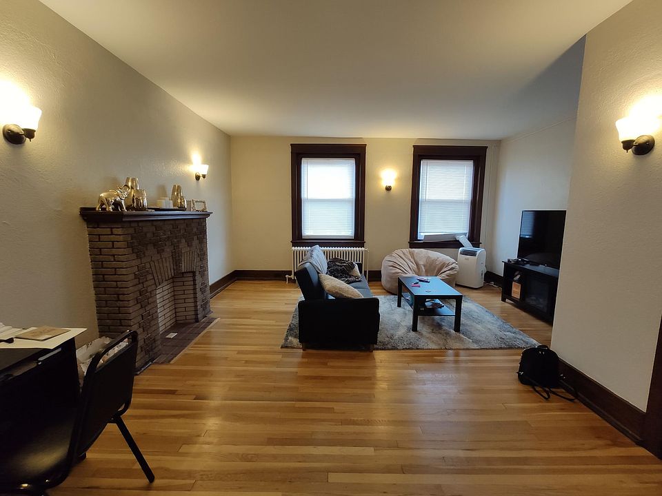 Huge living room with a fireplace as the focal point, and hardwood floors throughout the whole apartment