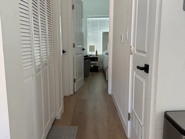 Hallway to second bedrom on the left and the main bedroom at the end of the hallway. The over/under washer/drive are located on the left side of the hallway as well.