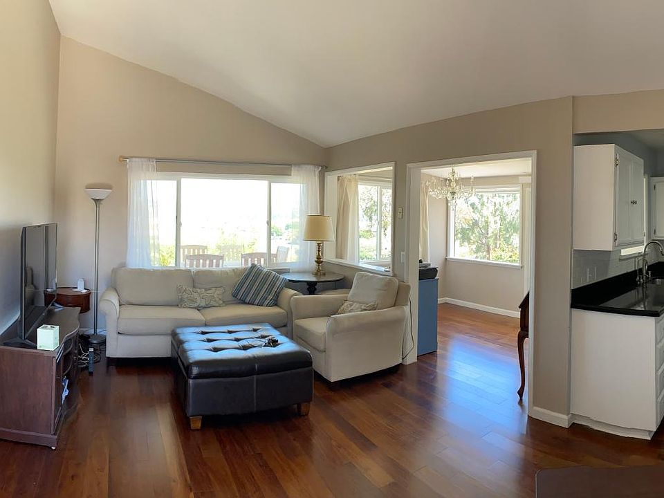 Panoramic showing open plan. Right to left: kitchen, dining, living, hallway to two bedrooms and bath
