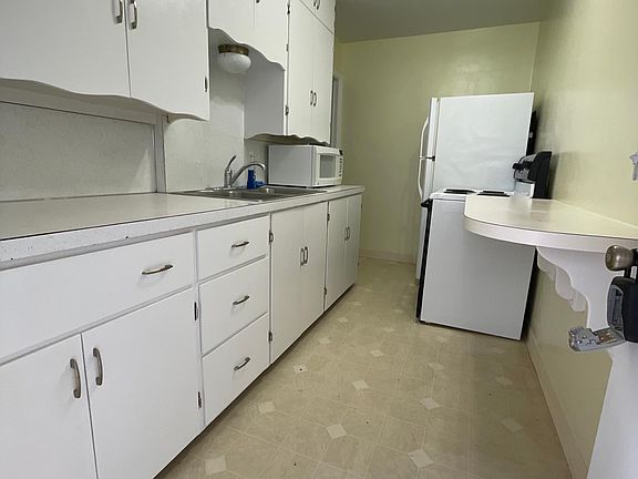 Kitchen with oven, refrigerator and microwave.