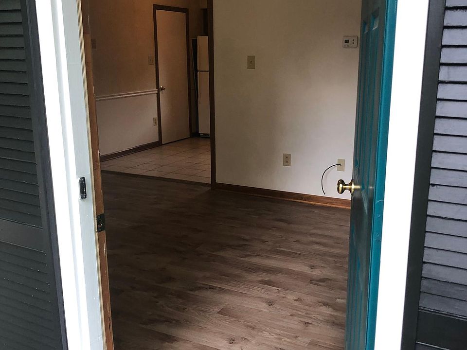 View of living room from the entry door, showing kitchen to the rear.