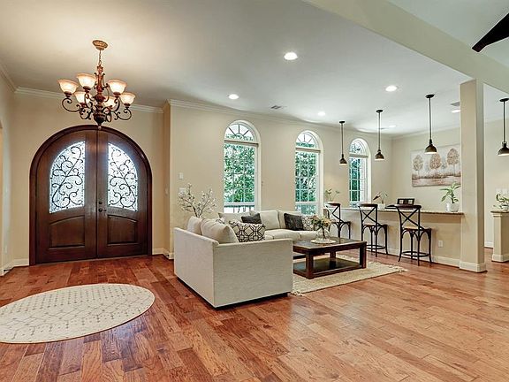 Open floor plan has access to living room, dining room, study/bar area and kitchen. Love the 3 arched windows that over look the front yard.