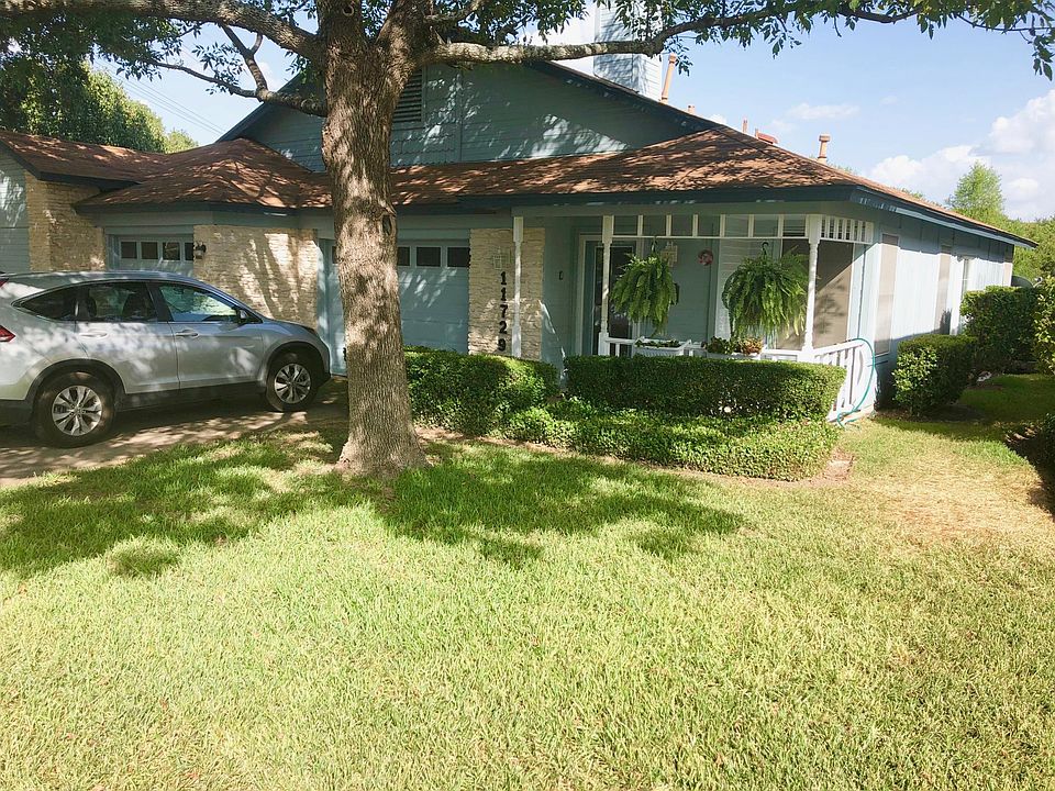 Front view of property showing lovely front porch, single car garage and beautiful shade tree.