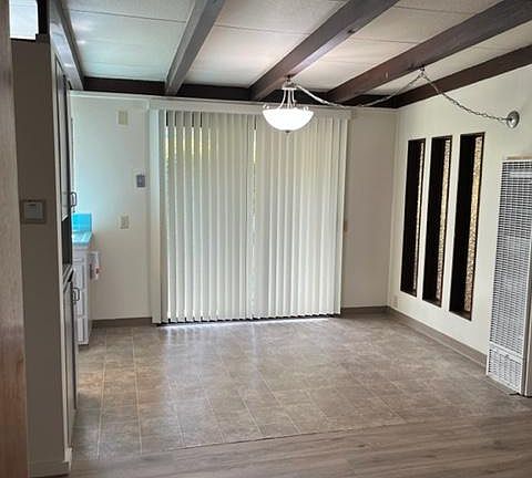 Dining area with sliding glass door to back patio/backyard. New vertical blinds and new hanging light.