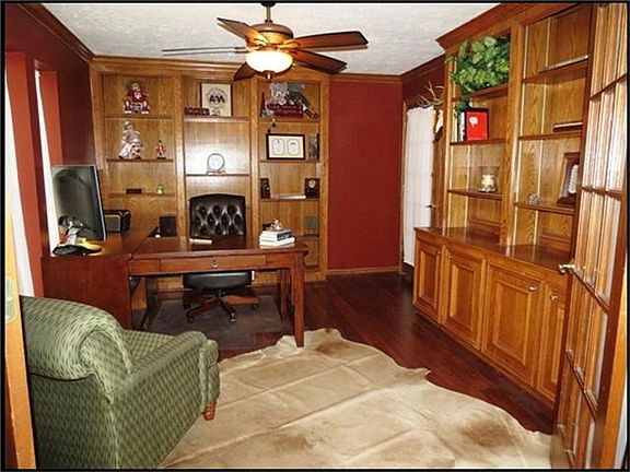  Executive study has built-in shelves, french doors, wood laminate floor, custom paint and ceiling fan.