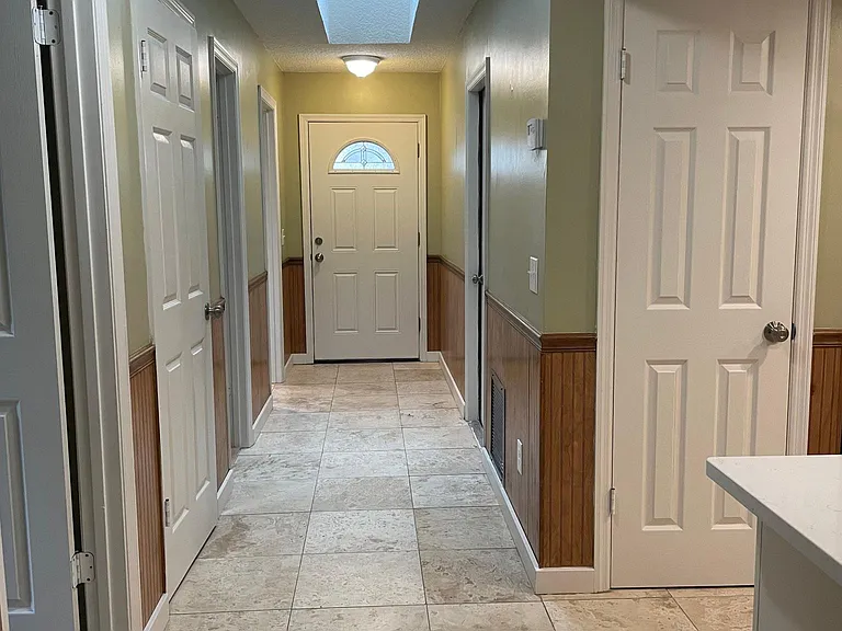 Front entryway view from inside house. Also showing location of hall closet and kitchen pantry