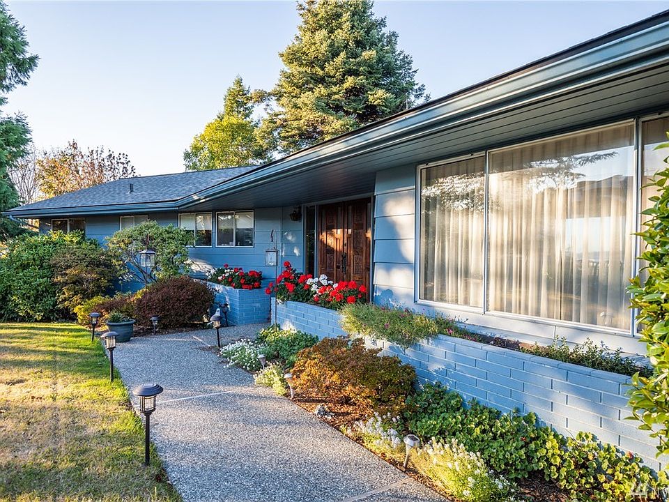 Sunny southern front yard with covered front entrance porch. 