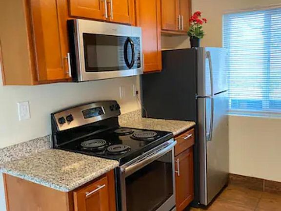nice, clean kitchen with stainless steel refrigerator, microwave and stove with oven.
