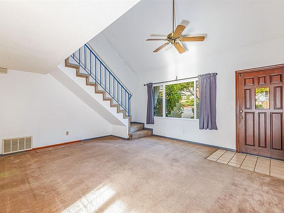 Living room with vaulted ceilings and ceiling fan.