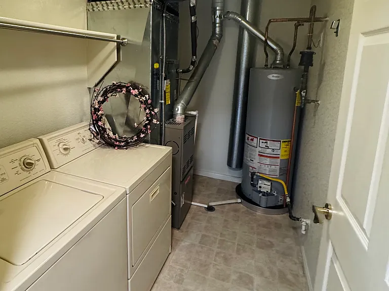 The laundry room is accessible through the kitchen and has a washer and dryer along with additional storage or pantry space.
