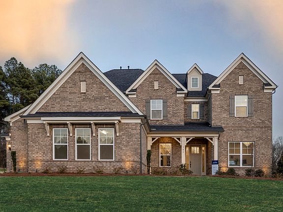 Hampton Exterior 18 features brick, covered front porch and 3 car sideload garage