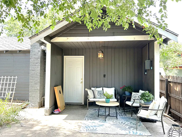 covered patio with 1 Car garage and work bench area