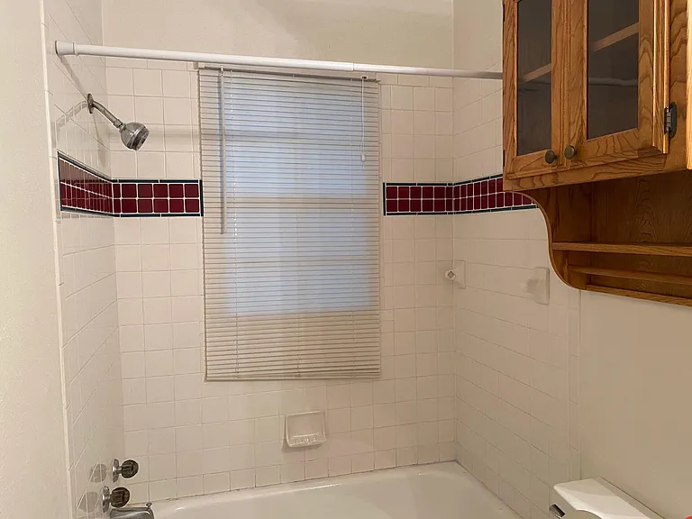 Master Bathroom - 9 ft. ceiling, full-size tub with shower, window with blind.