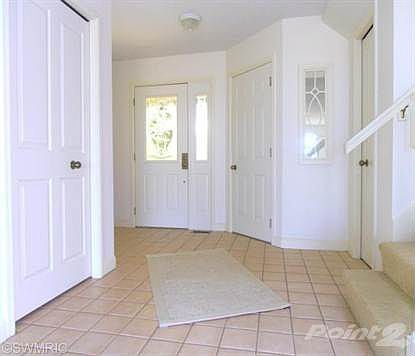 Broad, attractively designed entry foyer with  hall to half-bath on left of this view (not visible from this angle), door from garage on the right and ample guest closets.