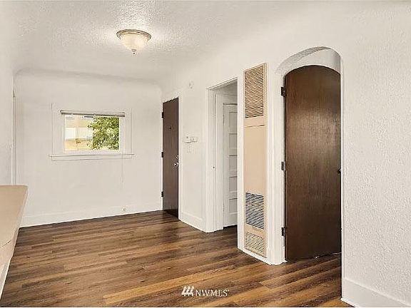 Another view of living room area and entry door.