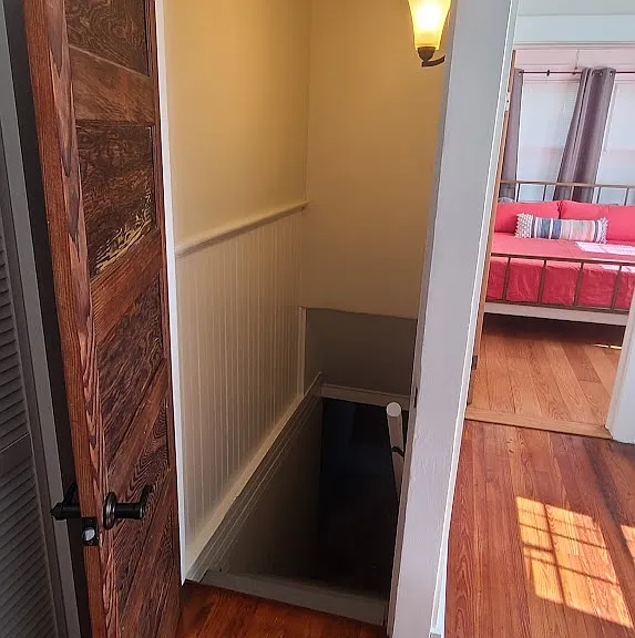 Interior stairwell with locking door in kitchen leads to 1st floor laundry/storage room and backyard area.