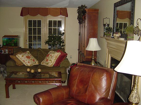 Open great room with fireplace & French doors to private deck